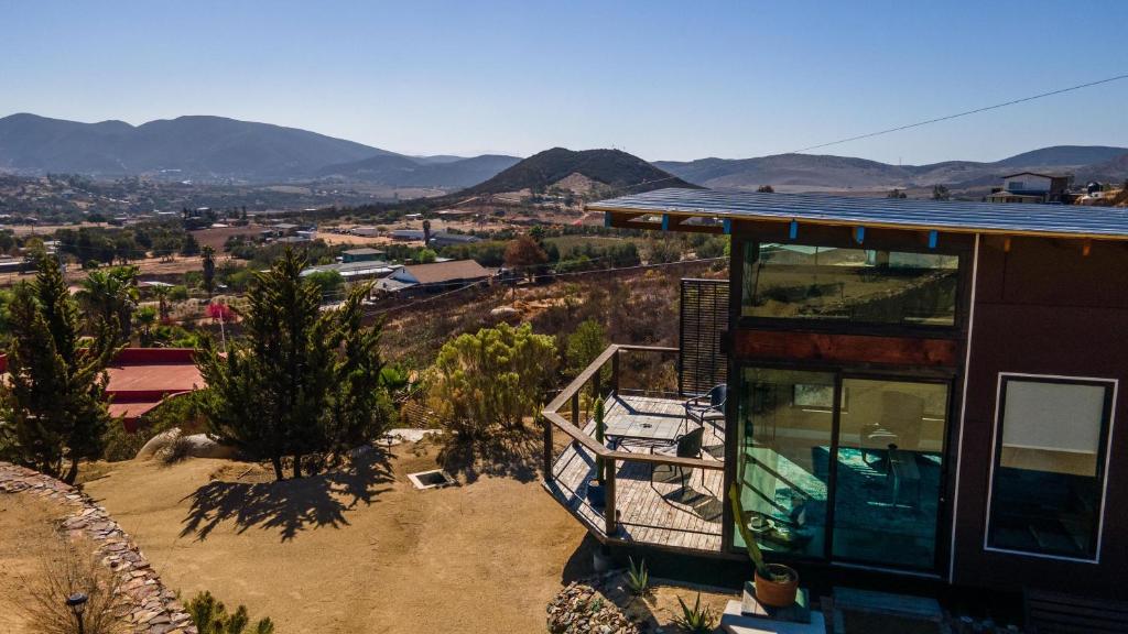 a house with a balcony with a view of a city at Rancho Cien Piedras in Valle de Guadalupe