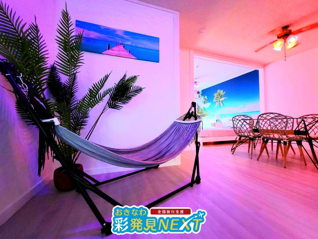a hammock in a room with a table and chairs at Villa Blu Okinawa Chatan 2-1 ヴィラブルー沖縄北谷2-1 "沖縄アリーナ徒歩圏内の民泊ホテル" in Chatan