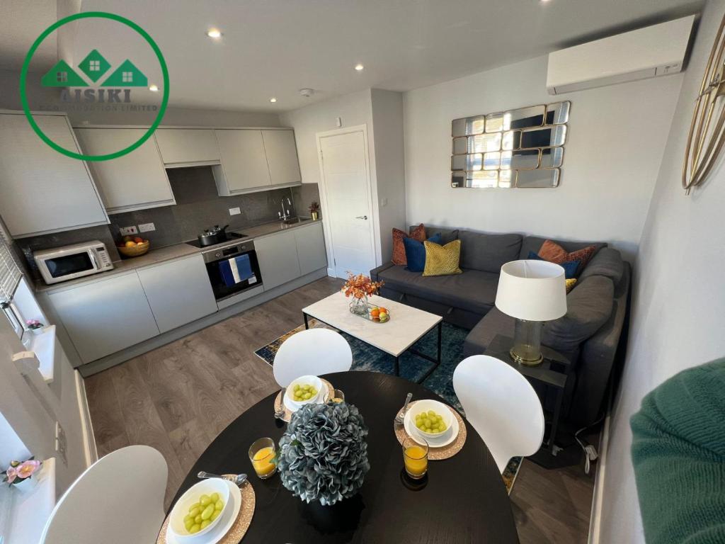 フィンチリーにあるAisiki Apartments at Stanhope Road, North Finchley, a Multiple 2 or 3 Bedroom Pet-Friendly Duplex Flats, King or Twin Beds with Aircon & FREE WIFIのリビングルーム(ソファ、テーブル付)
