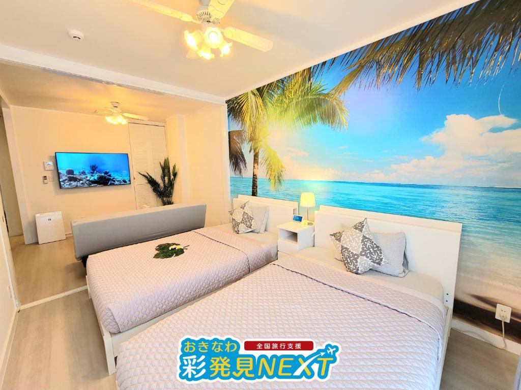 two beds in a room with a view of the ocean at Villa Blu Okinawa Chatan 3-2 ヴィラブルー沖縄北谷3-2 "沖縄アリーナ徒歩圏内の民泊ホテル" in Chatan