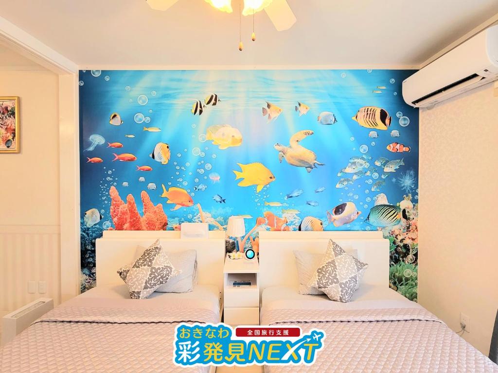 a bedroom with two beds with a fish wall mural at Villa Blu Okinawa Chatan 3-3 ヴィラブルー沖縄北谷3-3 "沖縄アリーナ徒歩圏内の民泊ホテル" in Chatan