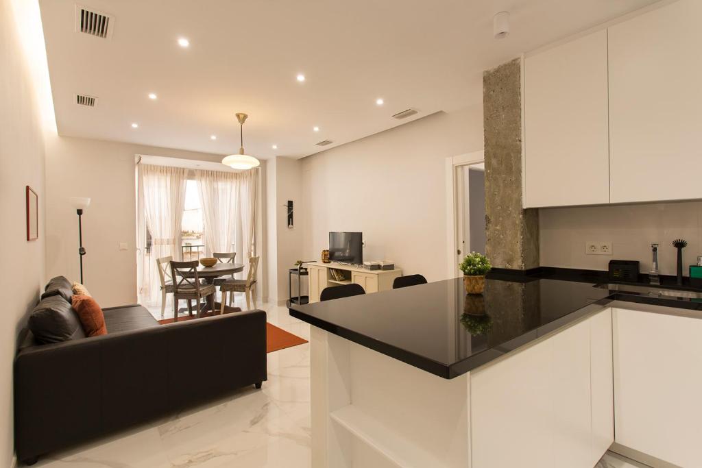 a kitchen and living room with a black counter top at Apartamento San Isidro Centro in Granada