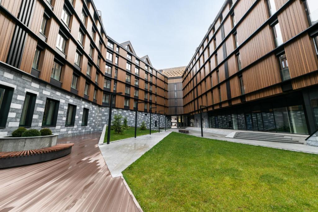 an empty courtyard of a building with a lawn at Aparthotel Woodside by Anaya in Kopaonik