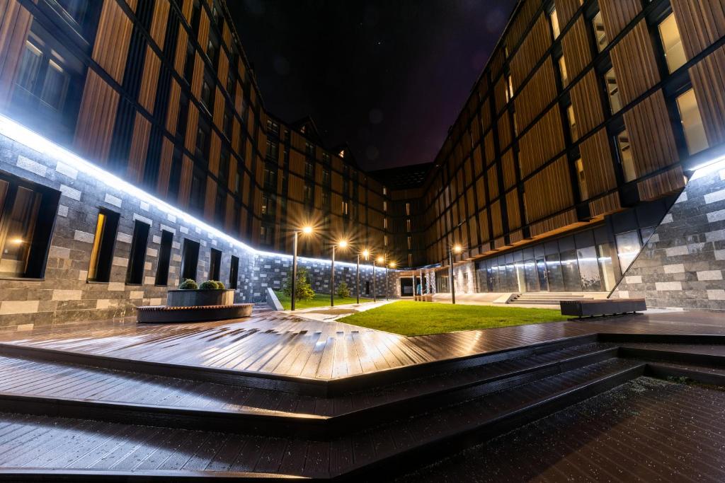 un edificio con un patio con luces por la noche en Aparthotel Woodside by Anaya, en Kopaonik