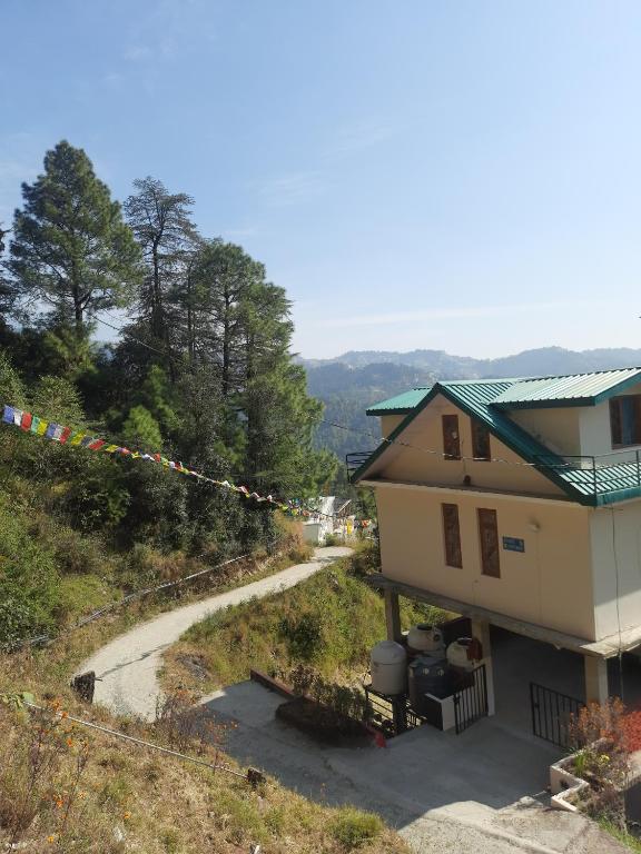 a house on a hill with a string of flags at Aagaman Woods Homestay in Shimla