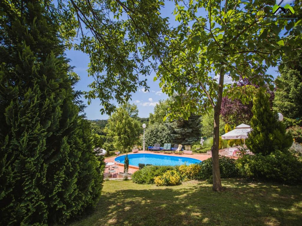 a swimming pool in a yard with trees at Holiday Home Boltar in Varaždin