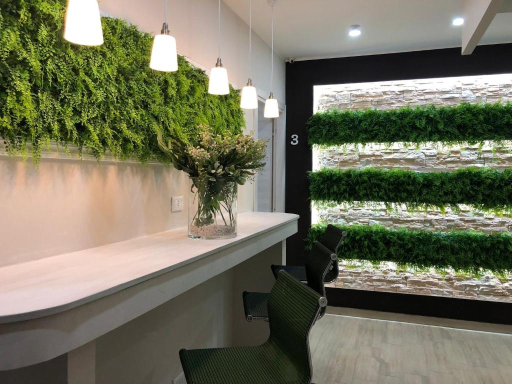 una hall con una parete verde e un vaso di fiori di Storico17 a Catania