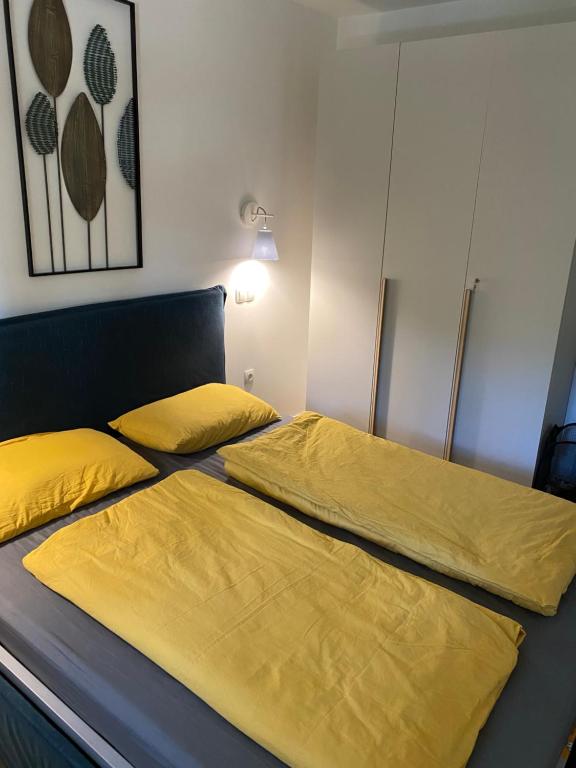 2 Betten in einem Schlafzimmer mit gelber Bettwäsche in der Unterkunft Golte Apartment Tibona in Mozirje