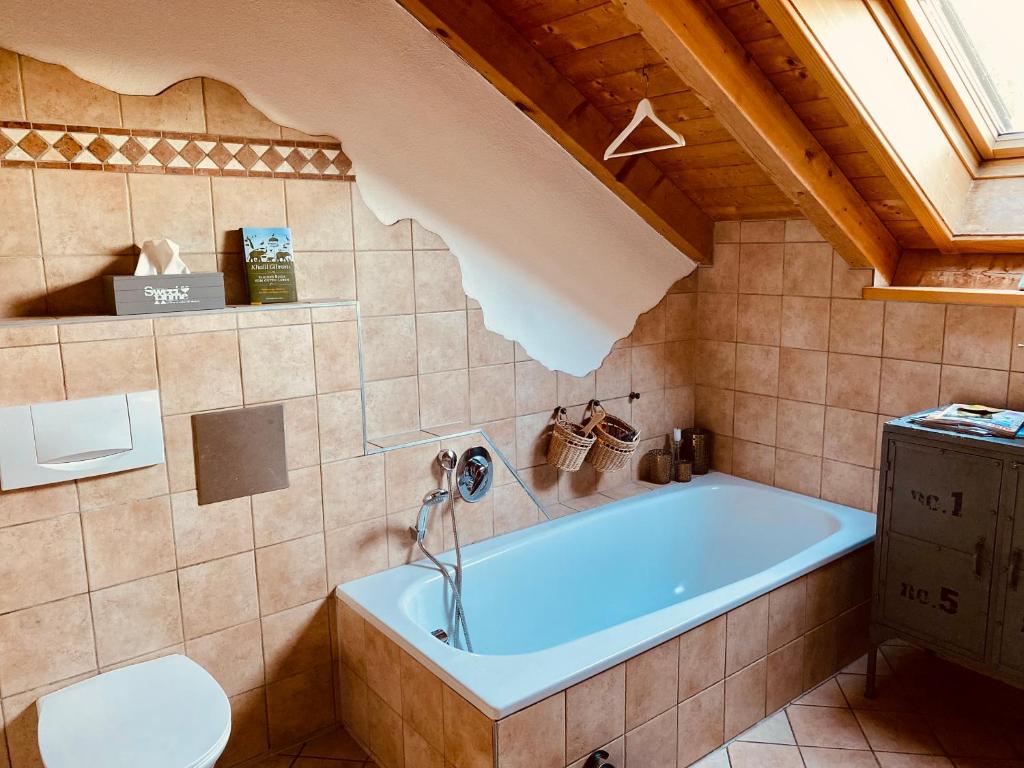 a bathroom with a tub and a toilet at Gemütliche Wohnung mit Ofen und Naturblick in Wildpoldsried