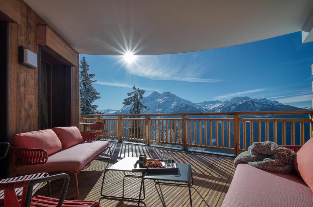 a balcony with couches and a view of mountains at Appartement Panorama, résidence Les Alpages in Montvalezan