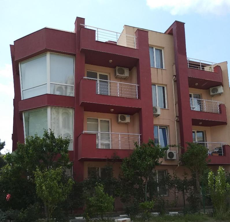 a red building with balconies on the side of it at Sunny houm in Nesebar