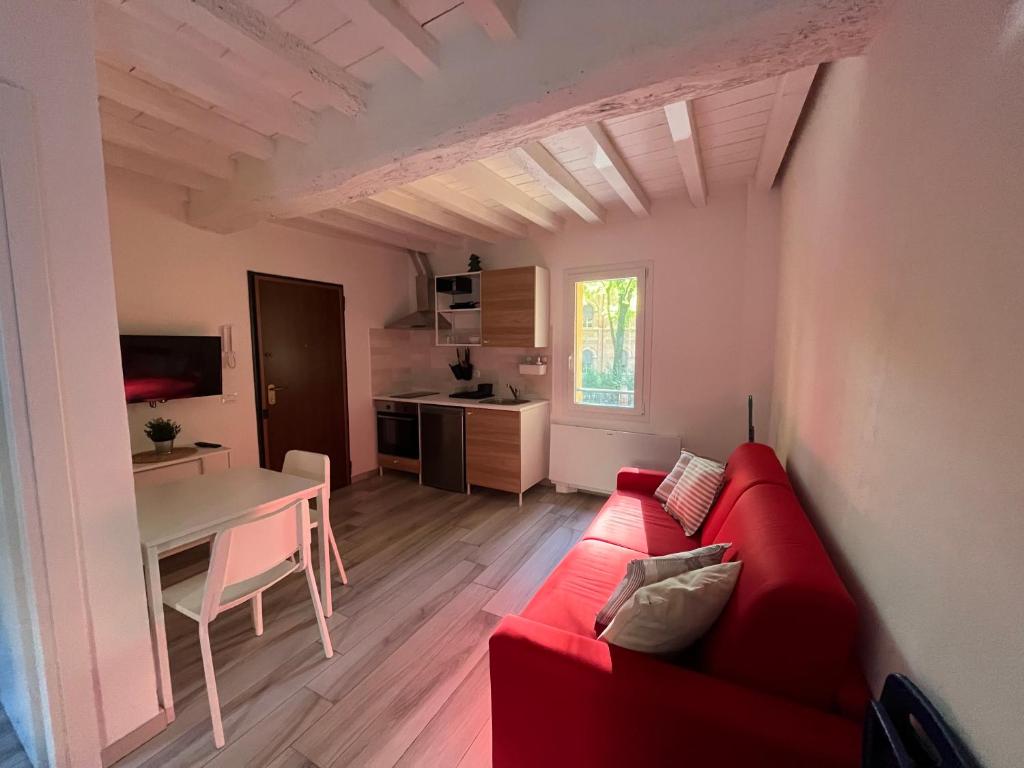 sala de estar con sofá rojo y mesa en Terrazza Montegrappa, en Reggio Emilia