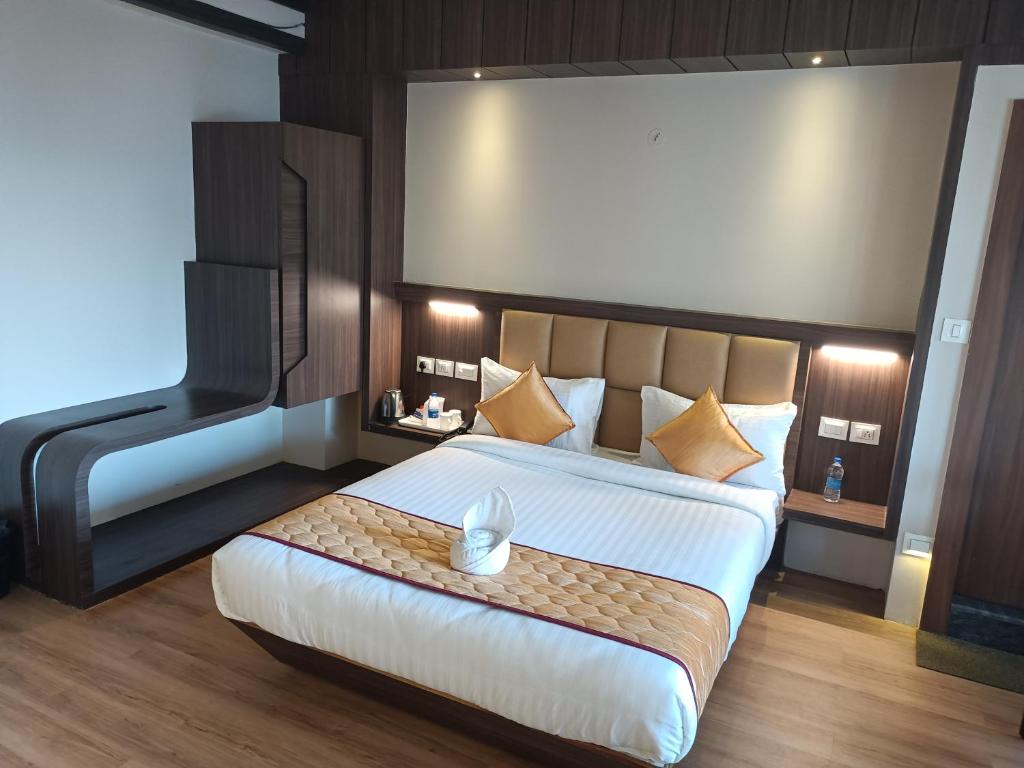 a bedroom with a large bed with a large headboard at Golden Peaks Hotel & Restaurant in Kalimpong