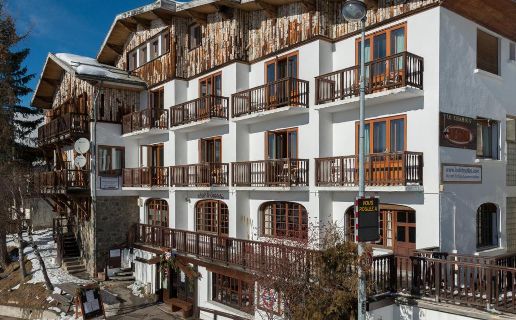 an apartment building with balconies on the side of it at Hotel Le Chamois in L'Alpe-d'Huez