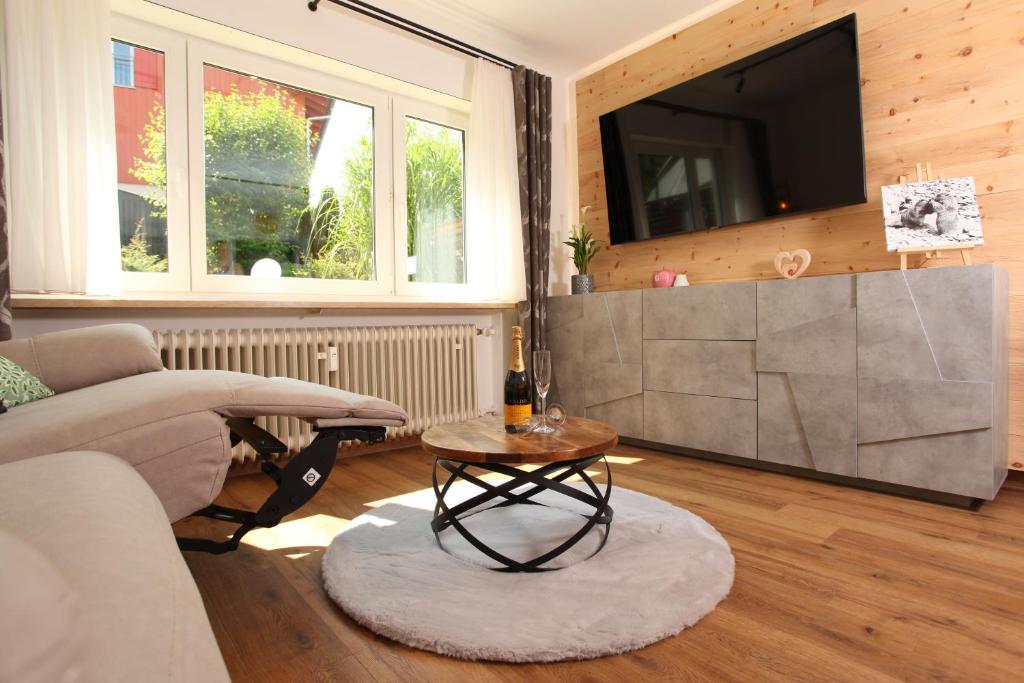 Una sala de estar con un sofá, un televisor y una mesa. en #demmi´s Zirbenstube, en Altstädten