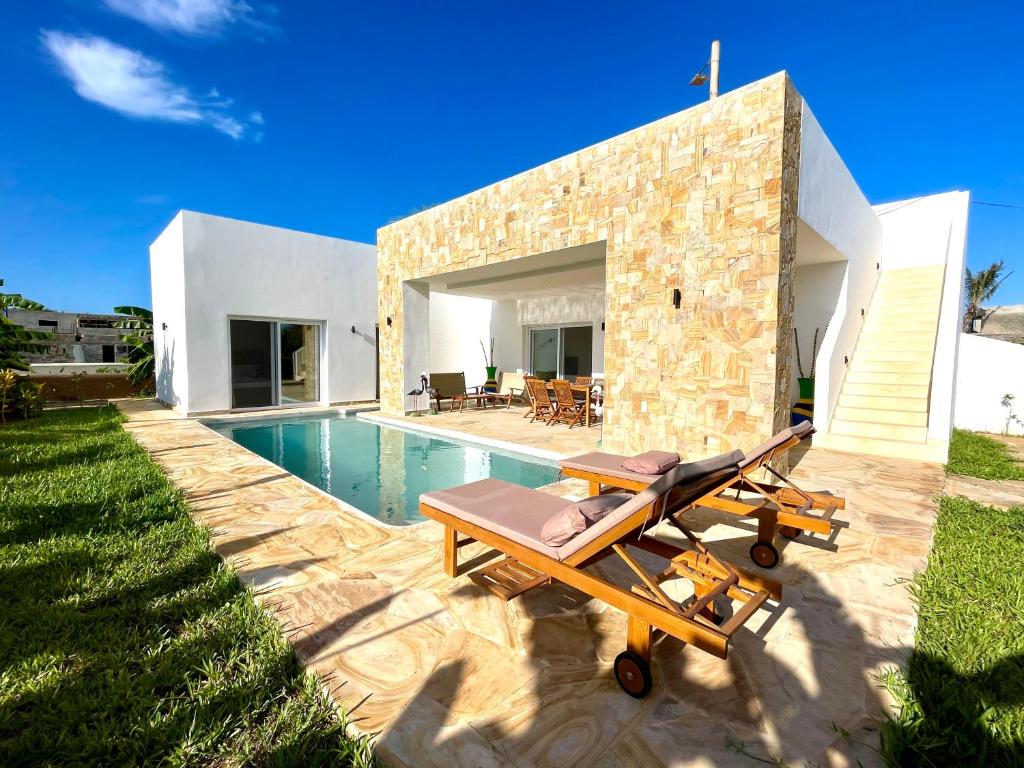 een villa met een zwembad en een patio bij Manami Villa with Private Pool ZanzibarHouses in Kiwengwa