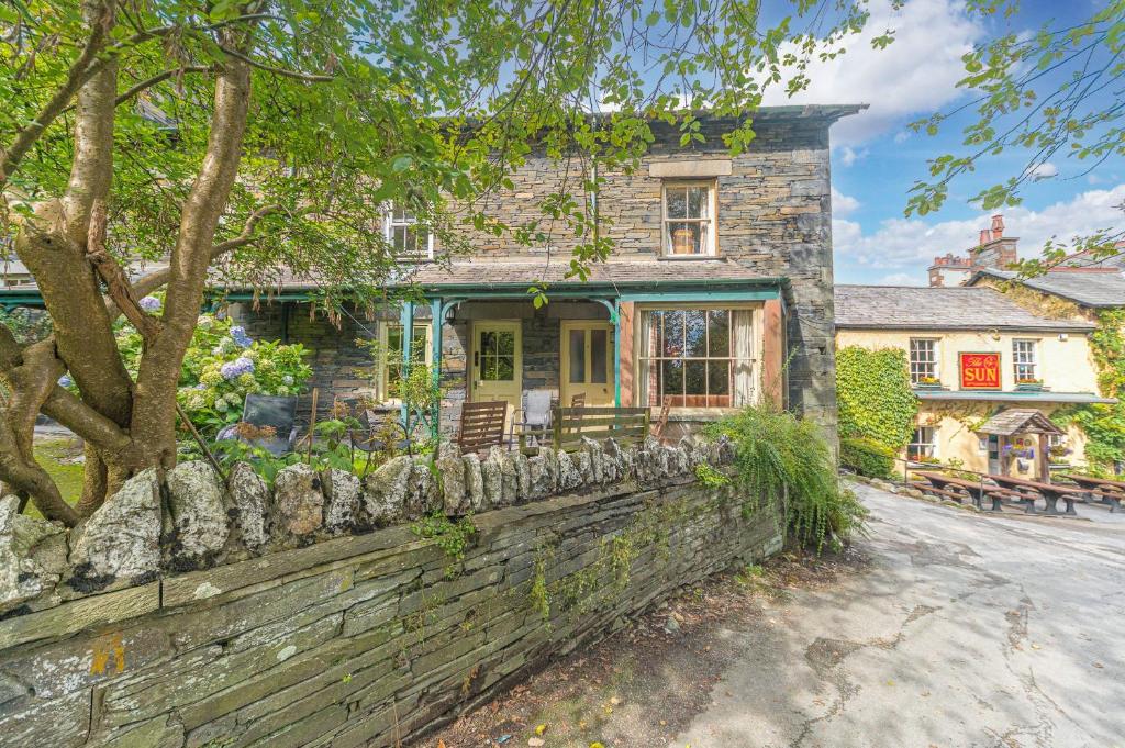 a stone house with a stone wall at 2 Dixon Ground Coniston in Coniston