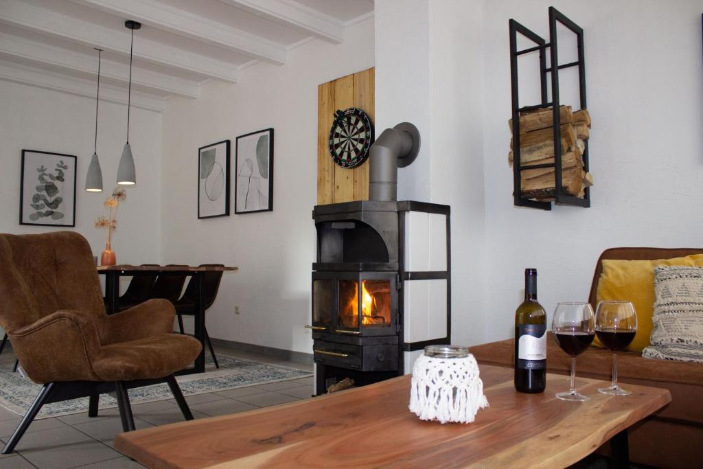 a living room with a fireplace and a table with wine glasses at Gemütliches Fachwerkhaus im Herzen Nideggens in Nideggen