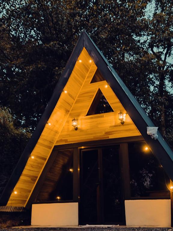 a house with a triangular roof at night at Pozas y Cascadas La Presa in Río Cuarto
