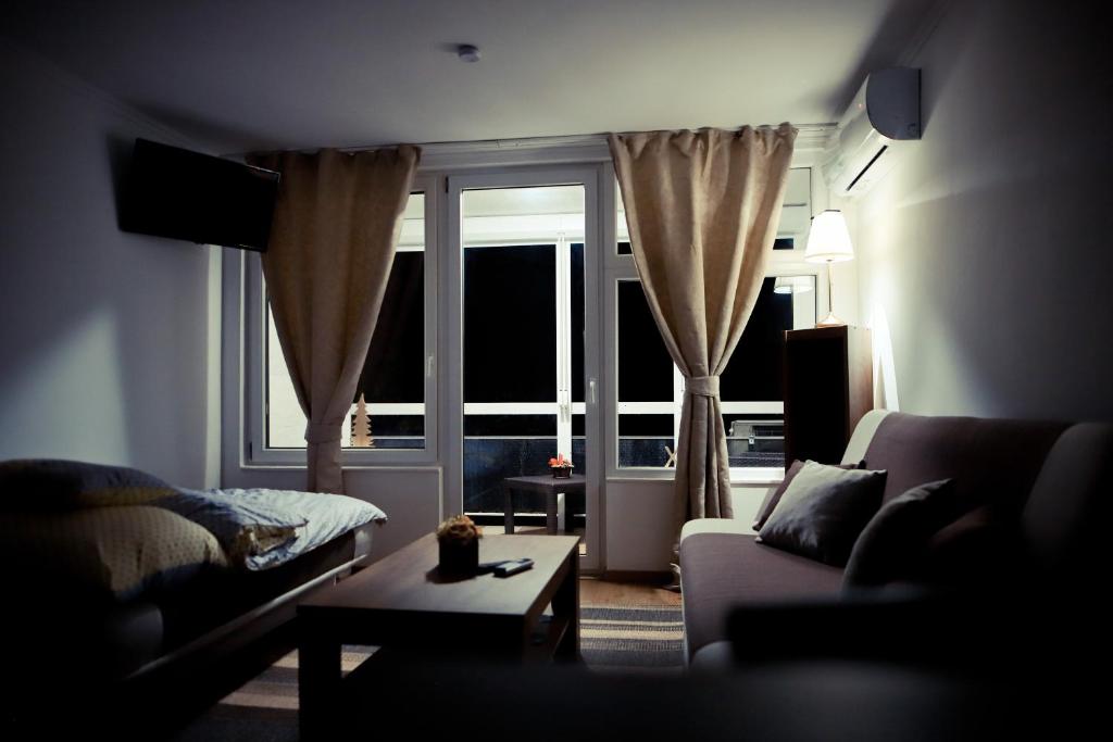 salon z kanapą i dużym oknem w obiekcie Mamma Mia Apartmanok w mieście Harkány