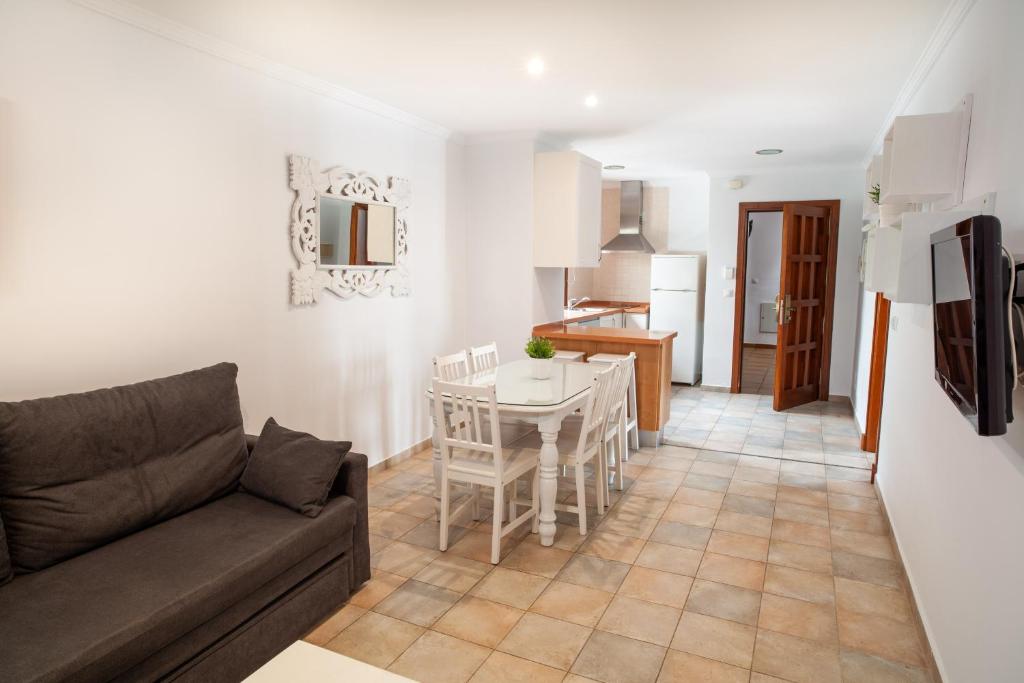 a living room and kitchen with a couch and a table at Apartamentos Gravina in Tarifa