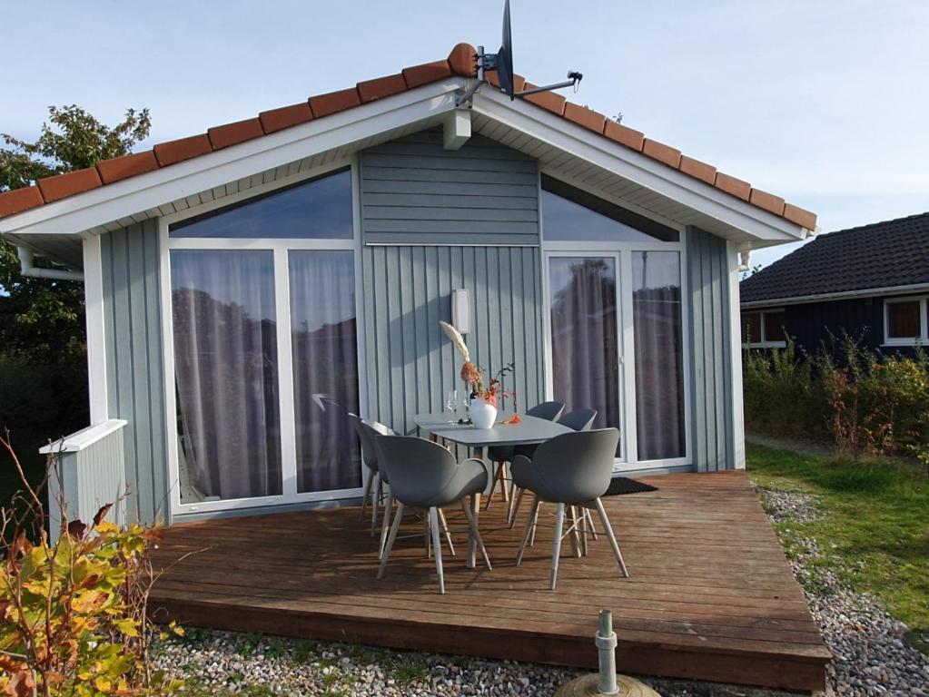 cenador con mesa y sillas en la terraza en Bootshus - Strandpark 15 en Grömitz