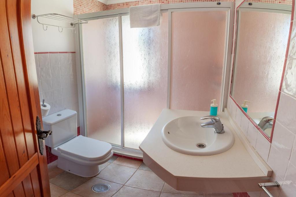 a bathroom with a shower and a sink and a toilet at Apartamentos Gravina in Tarifa