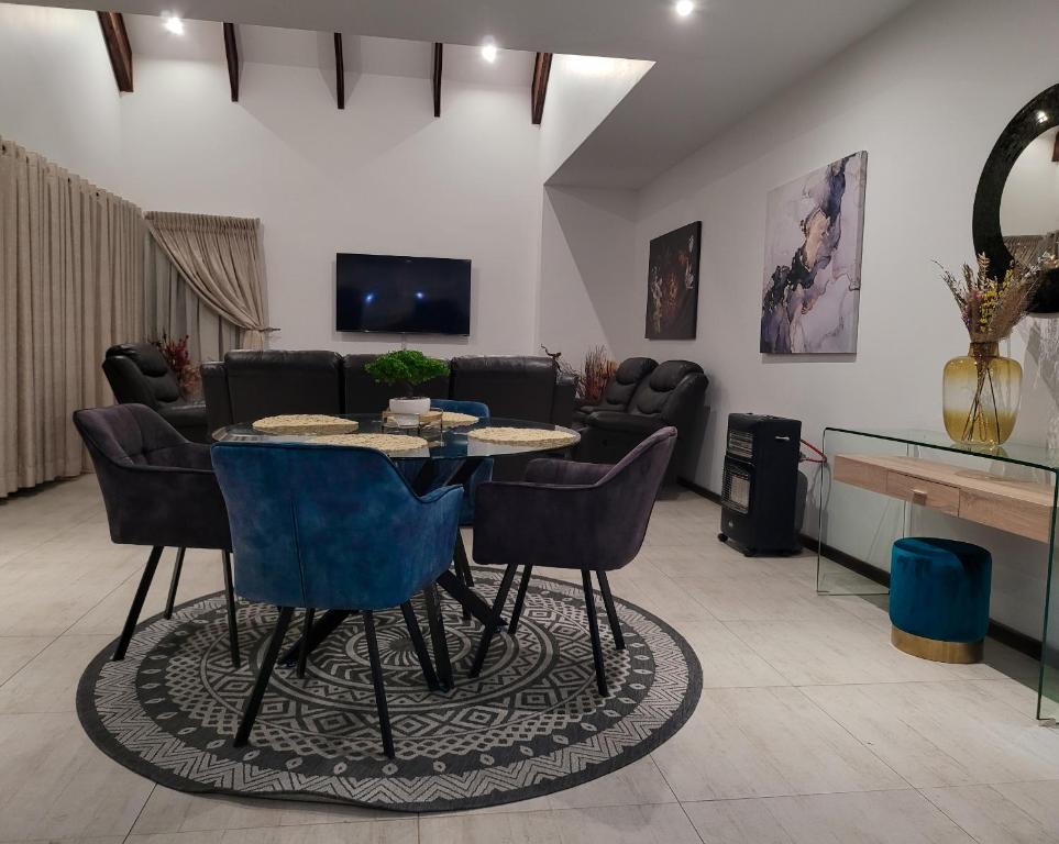 een woonkamer met een tafel en stoelen bij Sebs Chalet in Hartbeespoort
