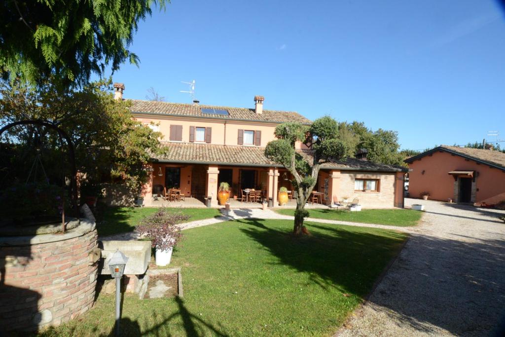 una casa grande con un patio delante en Agriturismo Maloura, en Savignano sul Rubicone