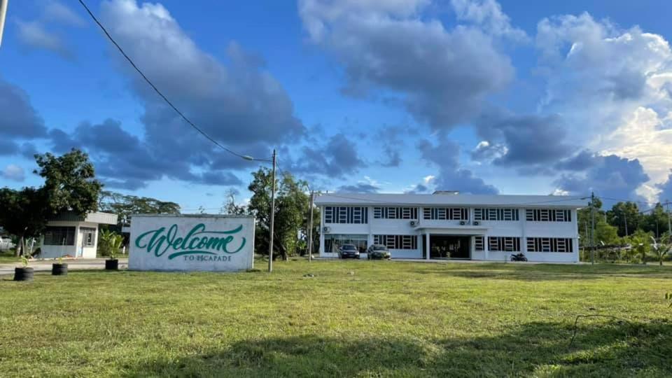 a large white building with a field in front of it at Dungun Escapade Resort in Dungun