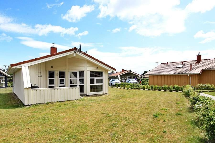 una casa blanca con un patio delante en Kapitänshus-Strandpark 24 en Grömitz