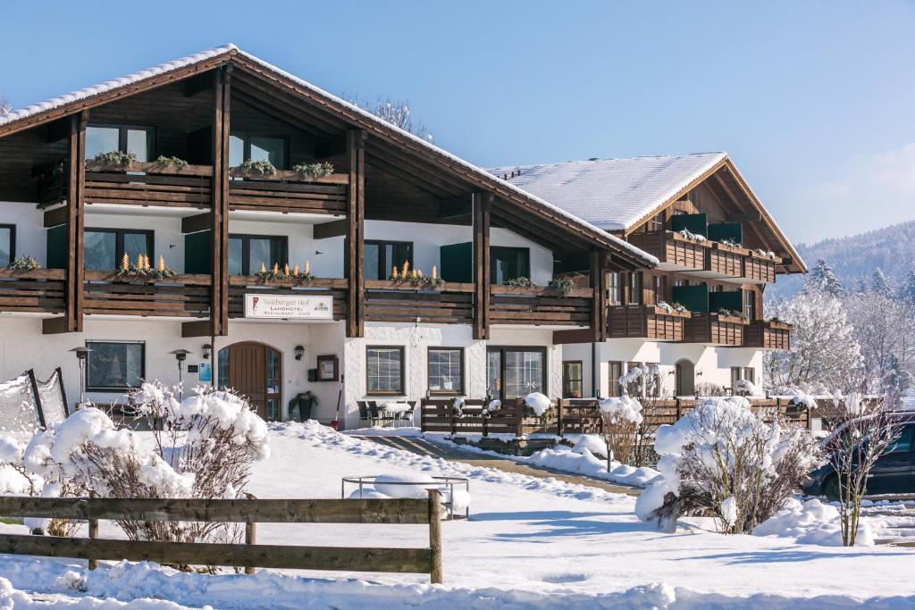 un gran edificio en la nieve con una valla en Sulzberger Hof, en Sulzberg