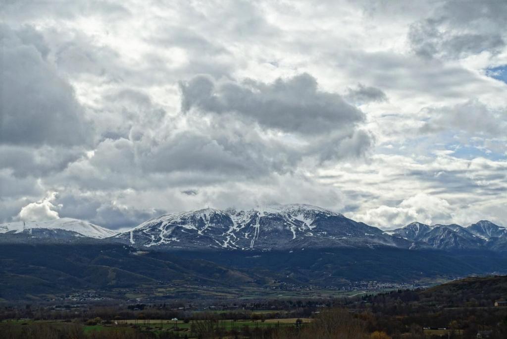 a snow covered mountain range under a cloudy sky at Domaine Agricole Cotzé &#47; Casa rural in Enveitg