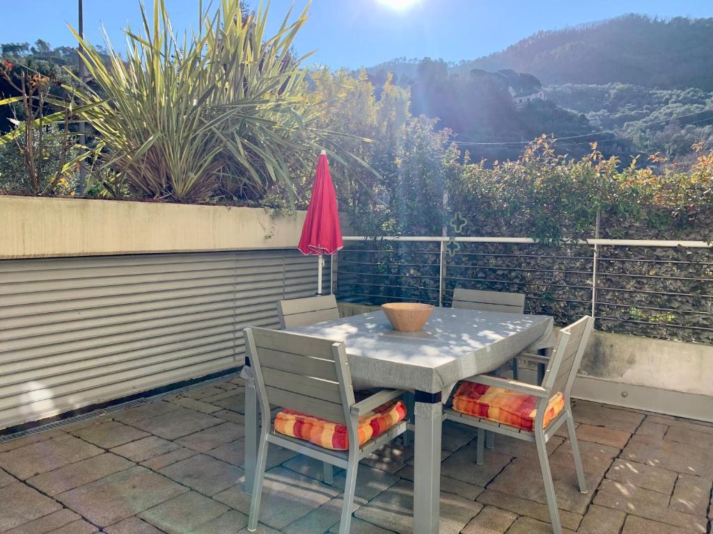 - une table avec 2 chaises et un parasol sur la terrasse dans l'établissement Appartamento Fiordaliso Residenza Prealba, à Levanto