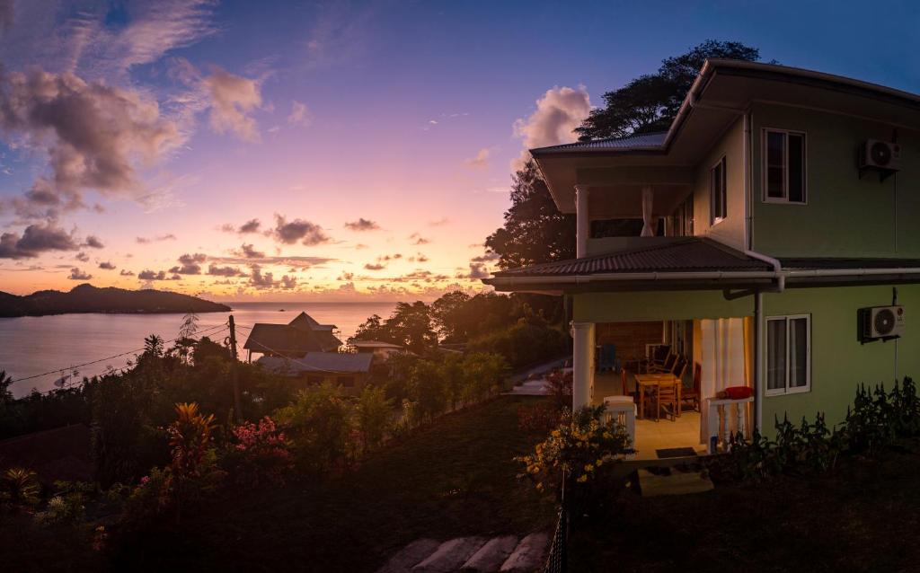 a house with the sunset in the background at TOP VIEW RETREAT SELFCATERING in Anse a La Mouche