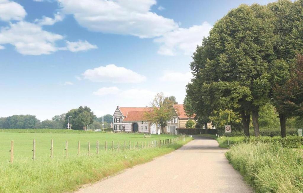 una strada sterrata che porta a una casa in un campo di Nieuwhuis Nuth a Nuth