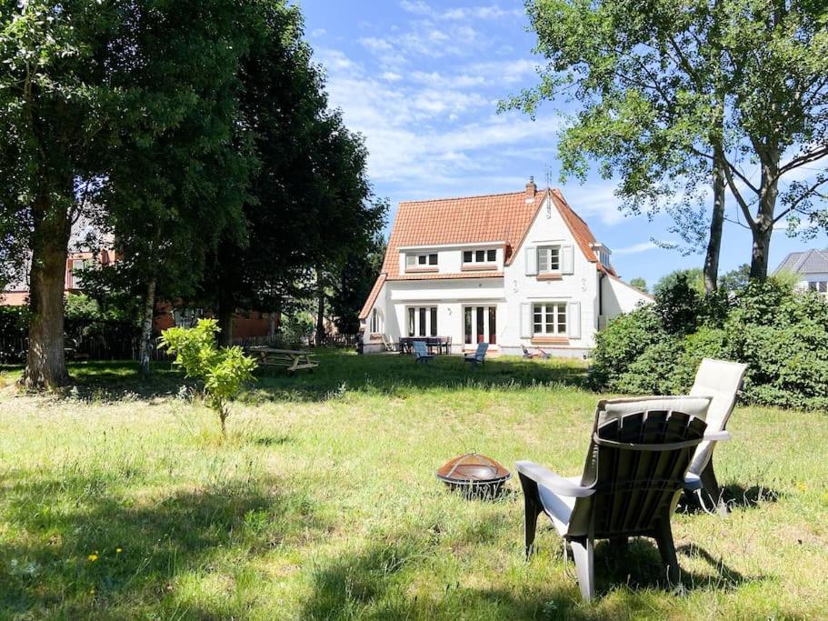 una silla sentada en el césped frente a una casa en Villa La Pastourelle - Cozy vacation house en Koksijde