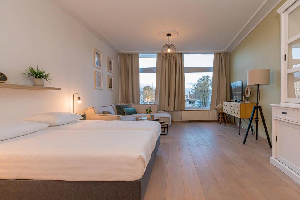 a hotel room with two beds and a living room at Twee Wijzen in Zierikzee