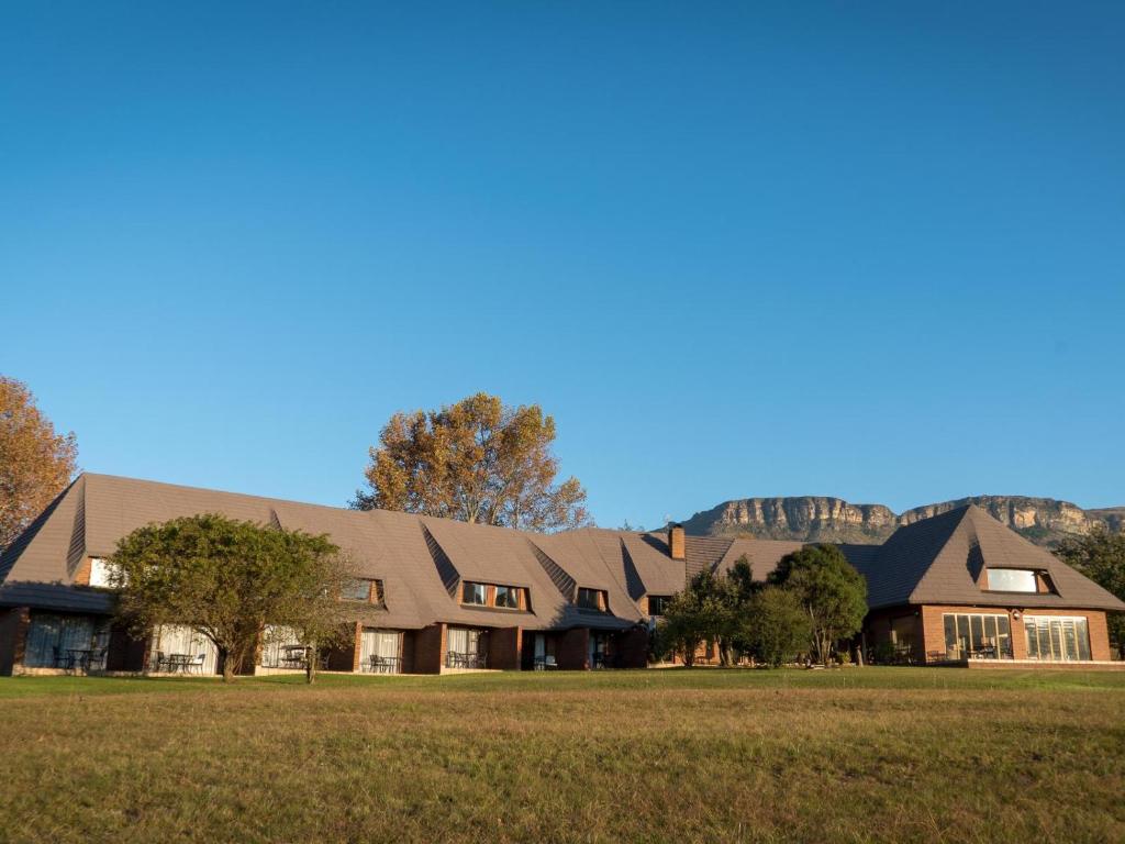 ein großes Haus mit einem Feld davor in der Unterkunft Silver Hill Lodge in Rev Estates