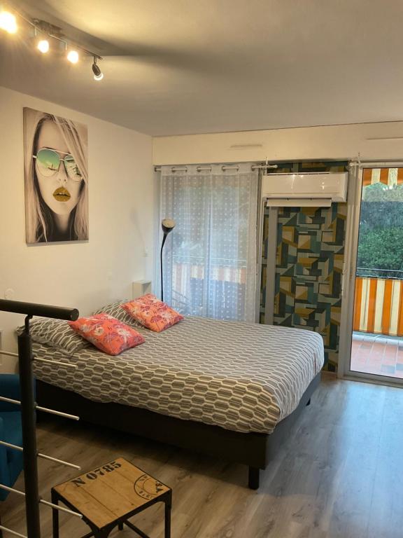 um quarto com uma cama e uma foto de uma mulher em Apartment Eden Park em Saint-Tropez