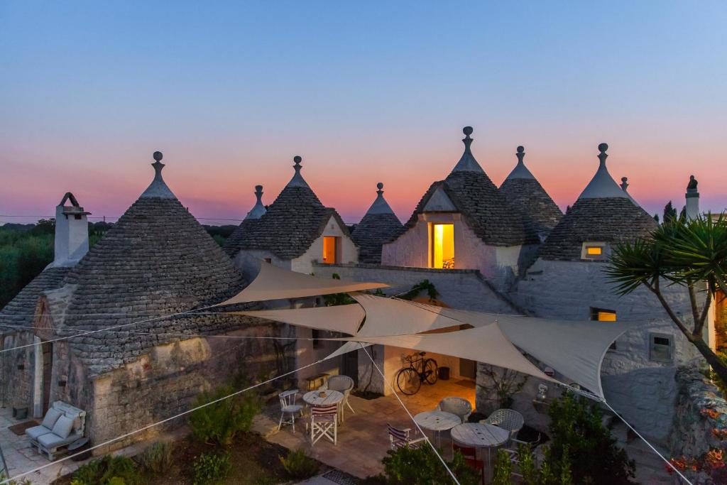 ein Haus mit einem Dach mit Sonnenschirmen davor in der Unterkunft Trulli 18cinquantanove in Cisternino