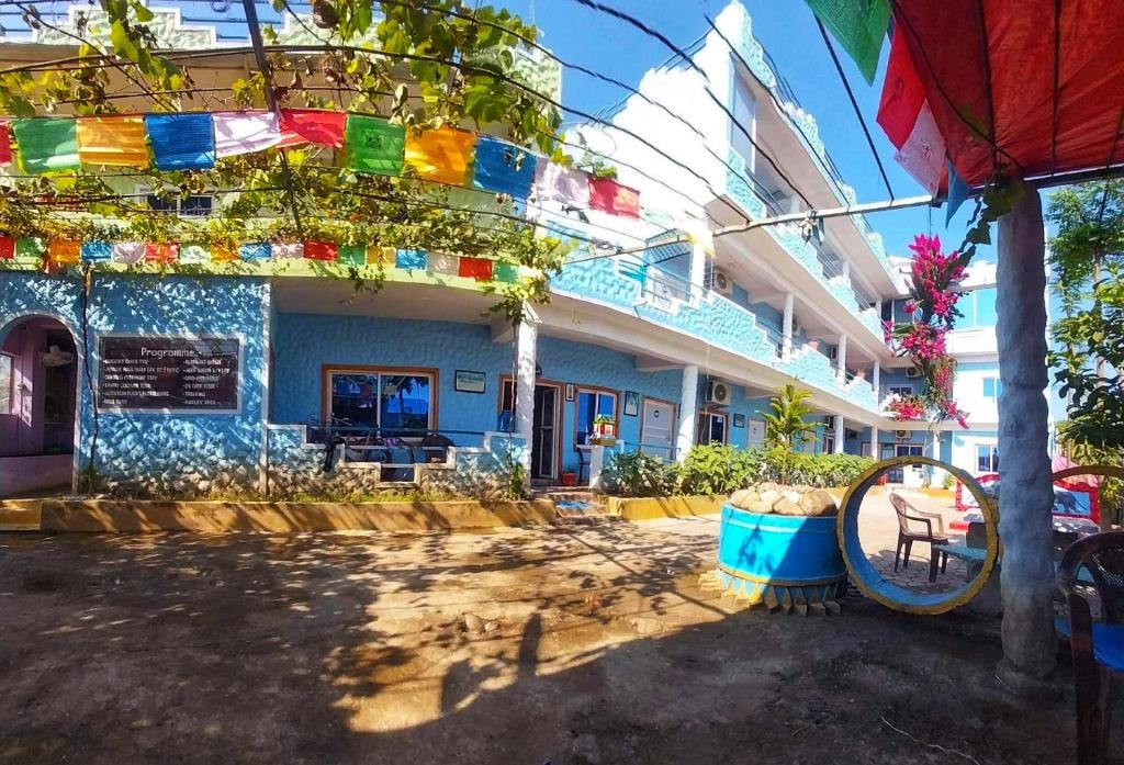 a blue building with a sign in front of it at Hong Qi Hotel in Chitwan