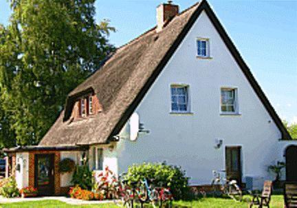 una gran casa blanca con techo de gambrel en Pension Fröhlich, en Gager