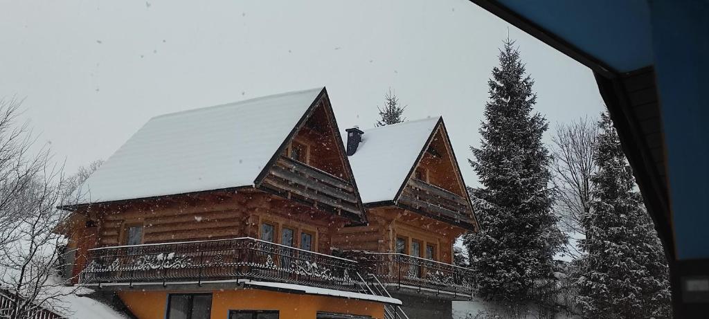 una gran casa de madera con nieve en el techo en Domek Góralski, en Zakopane