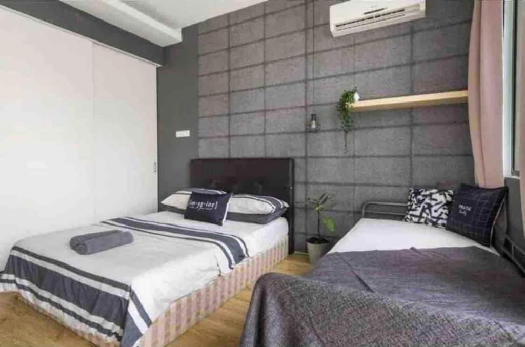a bedroom with two beds and a fireplace at Minimalist Studio Free Netflix/WiFi in Petaling Jaya