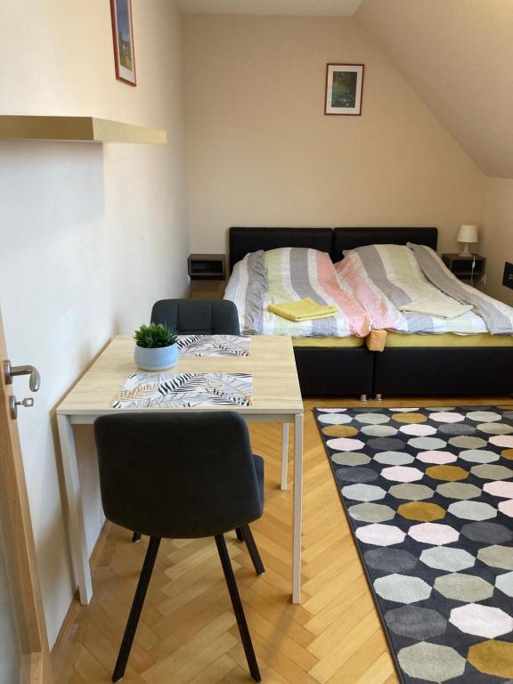1 dormitorio con mesa y 1 cama en Künszler Apartmanház en Zamárdi
