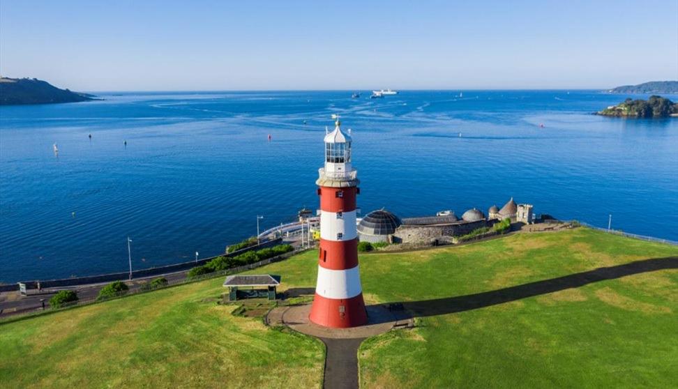 a red and white lighthouse sitting on top of a grass field at Luxury Accomodation close to city centre in Plymouth