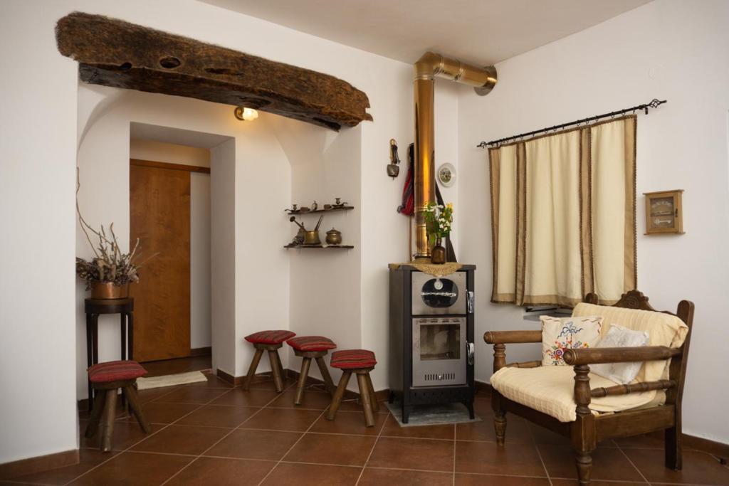 ein Wohnzimmer mit einem Stuhl und einem Herd in der Unterkunft Cottage home at South Chania in Grigorianá