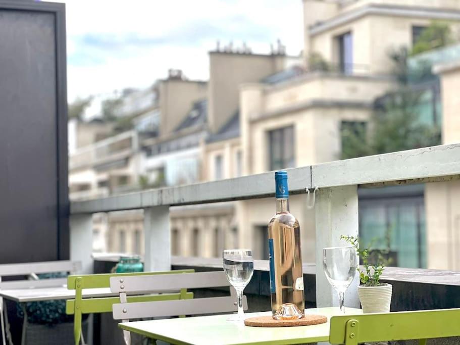une bouteille de vin posée sur une table avec deux verres dans l'établissement Champs Élysées-Belle terrasse, luxueux appartement, à Paris
