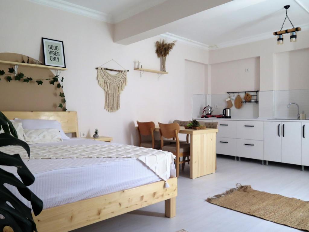 a bedroom with a bed and a table and a kitchen at Santa Suites- Near Saint Nicholas Church in Demre